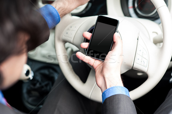 Man using mobile phone while driving Stock photo © stockyimages