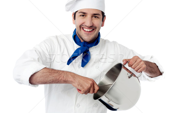 Smiling young chef holding vessel Stock photo © stockyimages