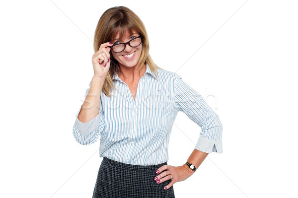 Cheerful corporate lady adjusting her spectacles Stock photo © stockyimages