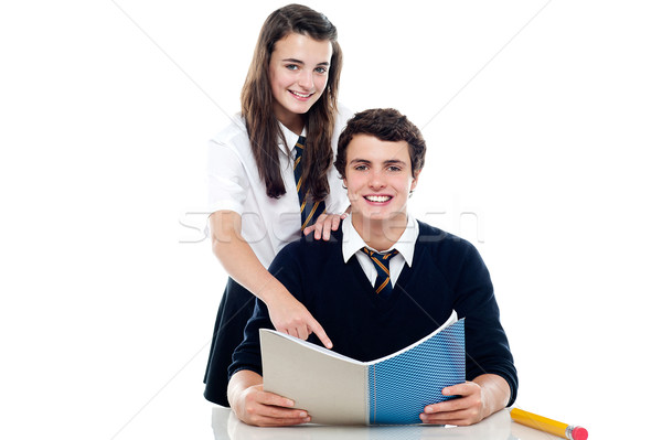 Girl pointing out the answer to her classmate Stock photo © stockyimages