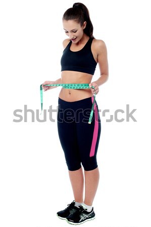 Slim fit woman measuring her waist Stock photo © stockyimages