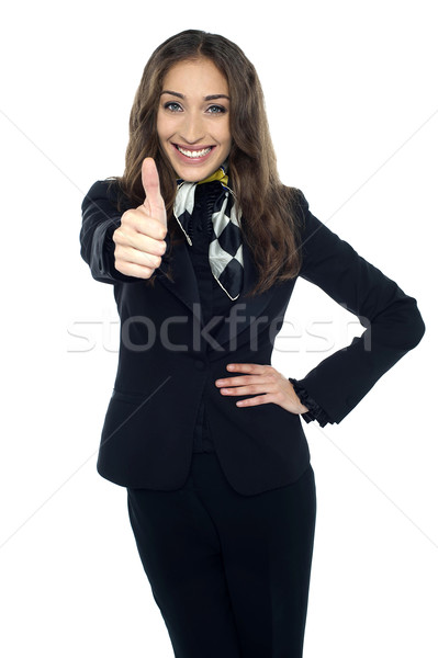 Joyous young stewardess gesturing thumbs up Stock photo © stockyimages