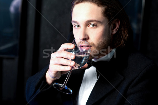 Guy in tuxedo drinking cocktail Stock photo © stockyimages