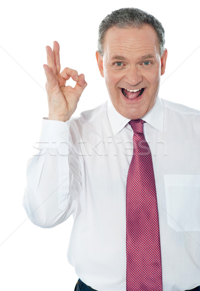 Happy satisfied businessman with okay hand sign Stock photo © stockyimages