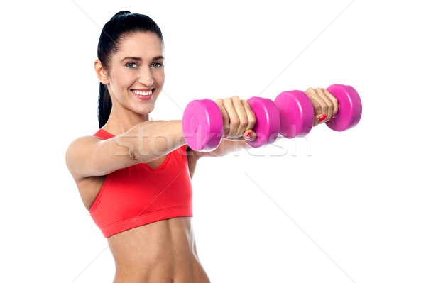 Joyous fit woman lifting dumbbells Stock photo © stockyimages