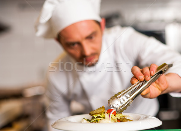 Chef arranging tossed salad in a white bowl Stock photo © stockyimages