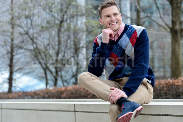 Stylish young man sitting in sidewalk Stock photo © stockyimages