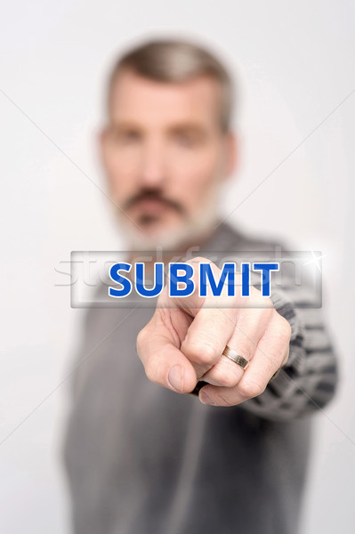 Man pressing virtual submit button Stock photo © stockyimages