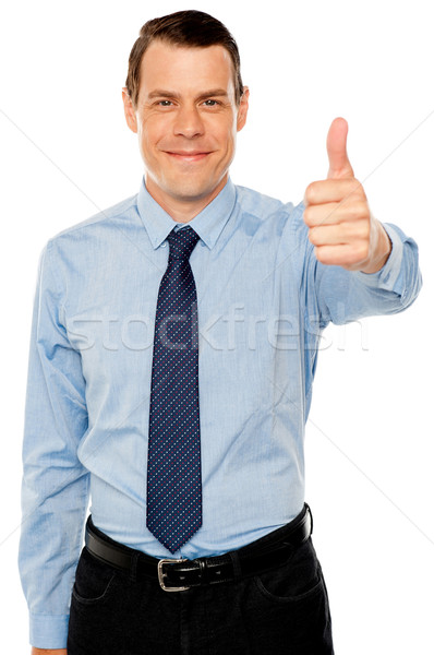 Smiling young man with thumbs up gesture Stock photo © stockyimages