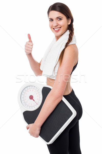 Happy Fitness woman with a weighing scale Stock photo © stockyimages