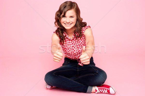 Pretty teenager showing double thumbs up Stock photo © stockyimages
