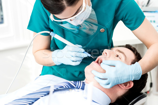 Professional dentist doing teeth checkup Stock photo © stockyimages