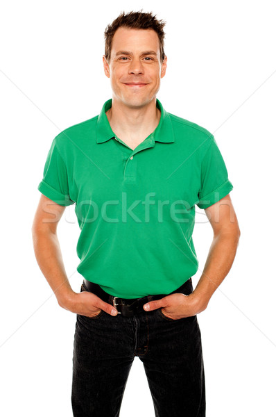 Smiling guy posing with hands in jeans pocket Stock photo © stockyimages