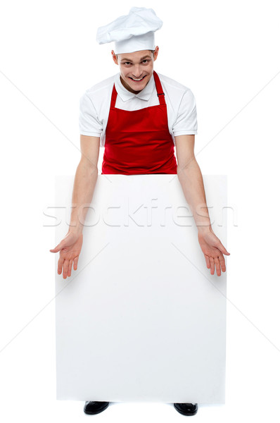 Handsome young cook showing blank billboard Stock photo © stockyimages