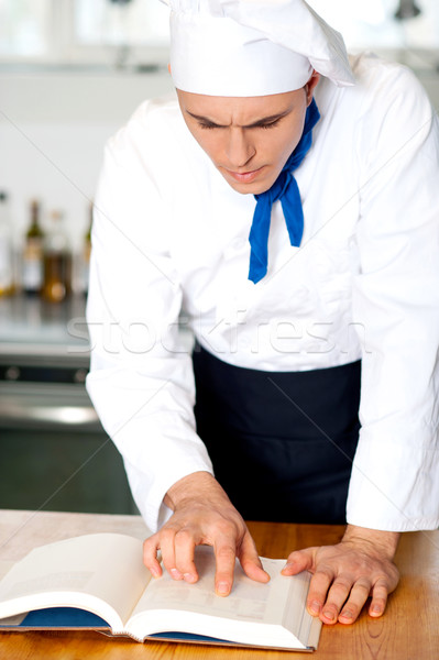 Male chef referring to cooking manual Stock photo © stockyimages