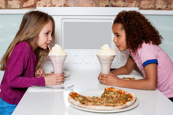 Young girls sipping strawberry shake Stock photo © stockyimages