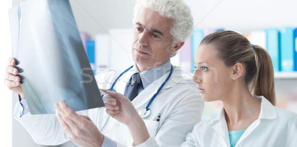 Radiologist checking an x-ray with his assistant Stock photo © stokkete