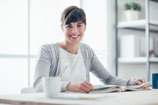 Mujer sonriente lectura libro sonriendo sesión Foto stock © stokkete