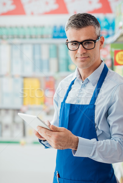 Supermarket clerk using a tablet Stock photo © stokkete