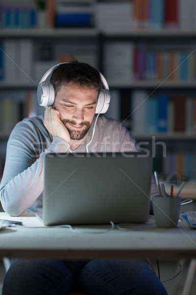 Smiling man networking late at night Stock photo © stokkete