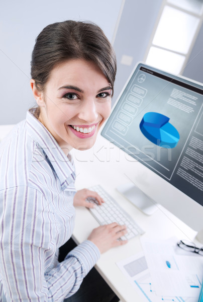 Cute businesswoman smiling at desk Stock photo © stokkete