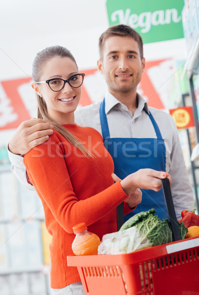Professional supermarket clerk and happy customer posing together, customer care and assistance conc Stock photo © stokkete