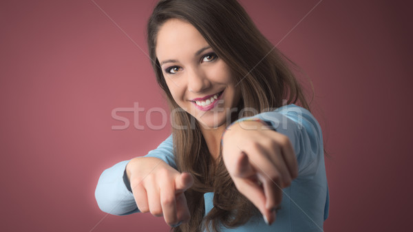 Smiling girl pointing at camera Stock photo © stokkete