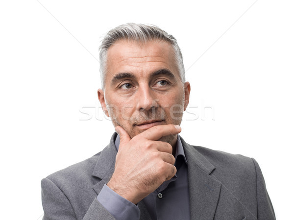 Smart businessman thinking with hand on chin Stock photo © stokkete