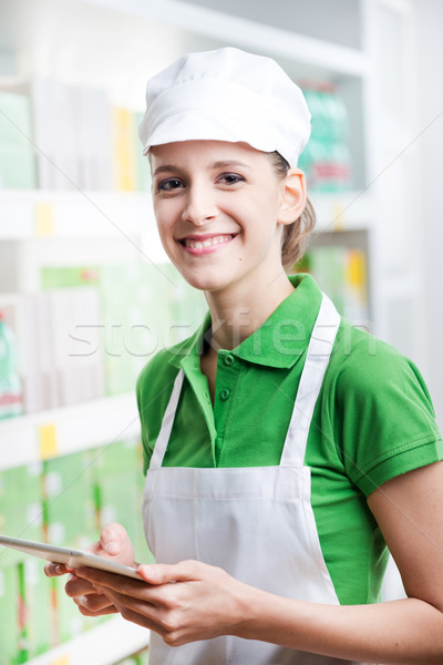 Female sales clerk with tablet at supermarket Stock photo © stokkete