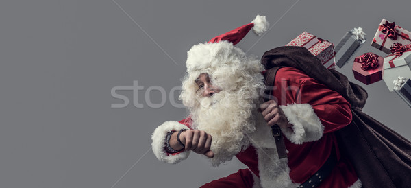 Santa Claus running and delivering gifts Stock photo © stokkete