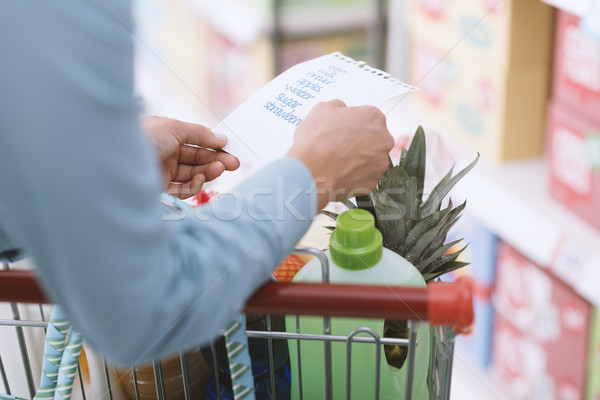 Mulher compras lista mercearia supermercado empurrando Foto stock © stokkete