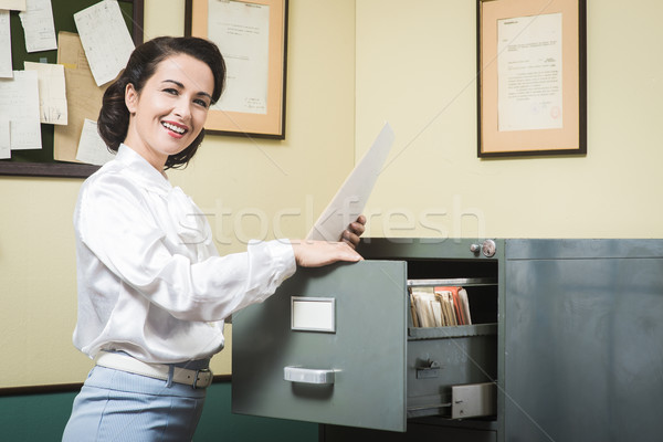Glimlachend secretaris zoeken bestanden kabinet vintage Stockfoto © stokkete