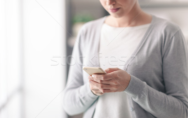 Młoda kobieta sms komórkowych ekran dotykowy telefonu Zdjęcia stock © stokkete