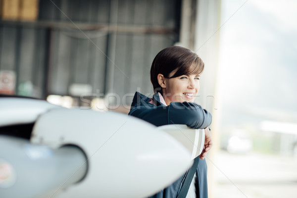 Vrouwelijke piloot jonge poseren licht vliegtuigen Stockfoto © stokkete