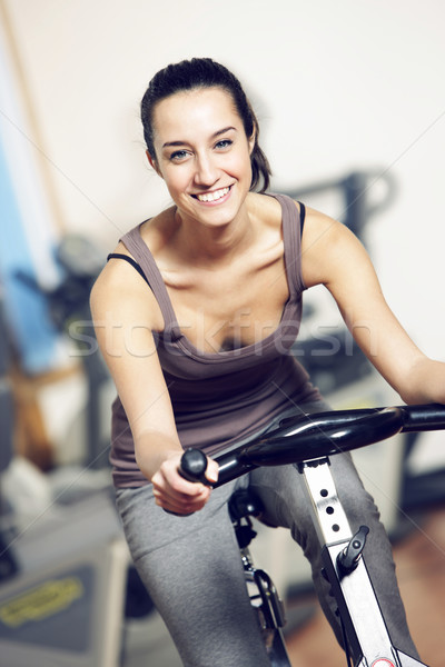 A young woman riding an exercise bike Stock photo © stokkete