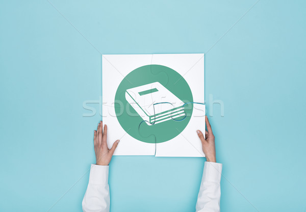 Woman completing a puzzle with book icon Stock photo © stokkete
