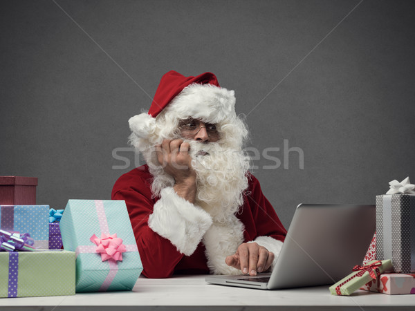 Disappointed Santa Claus connecting with his laptop Stock photo © stokkete
