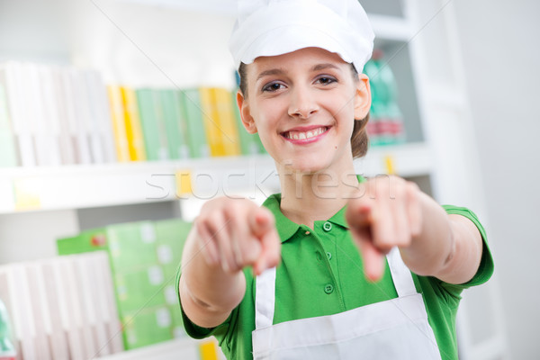 Sales clerk smiling and pointing at camera Stock photo © stokkete