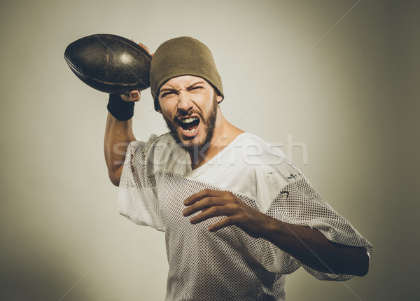 Stock photo: Handsome football player with ball