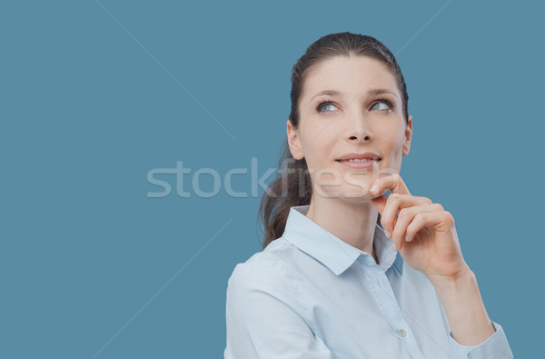 Confident woman thinking with hand on chin Stock photo © stokkete