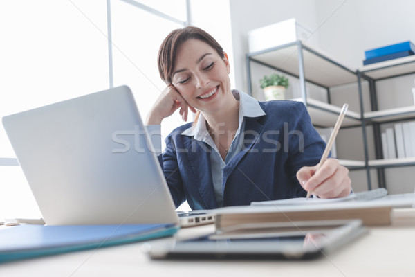 Businesswoman writing notes on a notebook Stock photo © stokkete