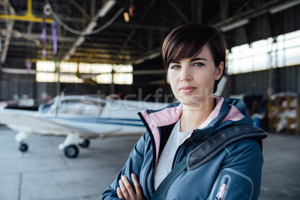 Confident female pilot posing in the hangar Stock photo © stokkete