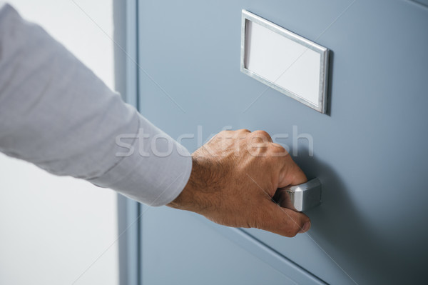 Businessman opening a filing cabinet drawer Stock photo © stokkete