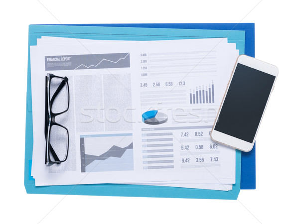 Smart phone and financial reports Stock photo © stokkete