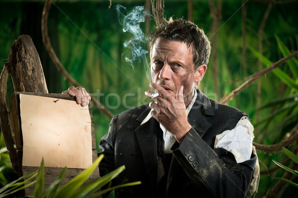 Stock photo: Businessman smoking in the jungle