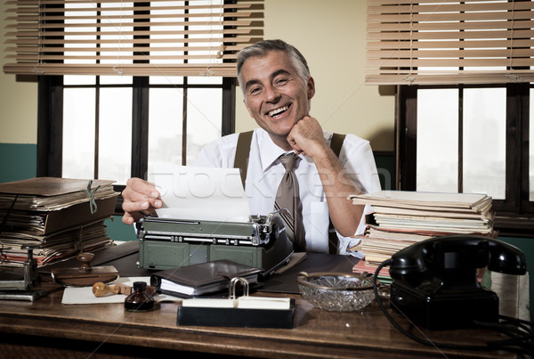 Smiling retro reporter working at office desk Stock photo © stokkete