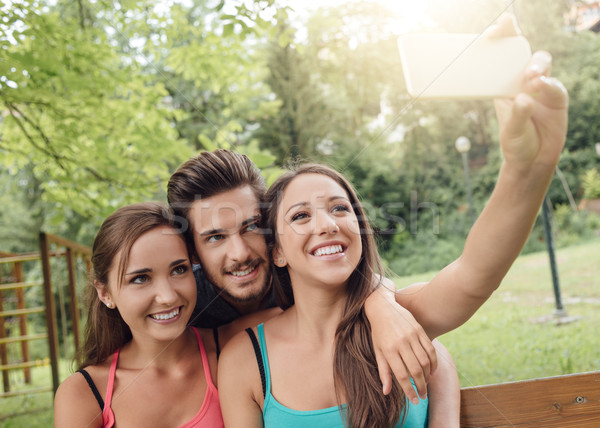 Stock photo: Cheerful teens at the park taking selfies