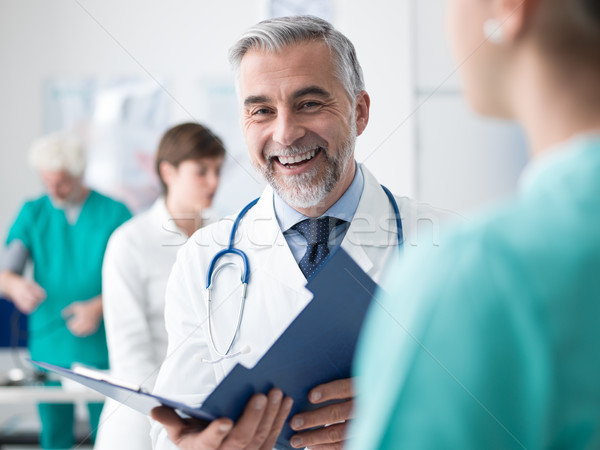 Orvos megvizsgál orvosi lemezek mosolyog profi Stock fotó © stokkete