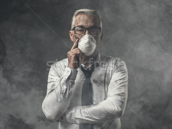 Businessman with mask and air pollution Stock photo © stokkete