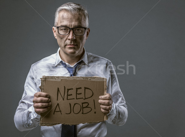 Broke jobless businessman holding a cardboard sign Stock photo © stokkete